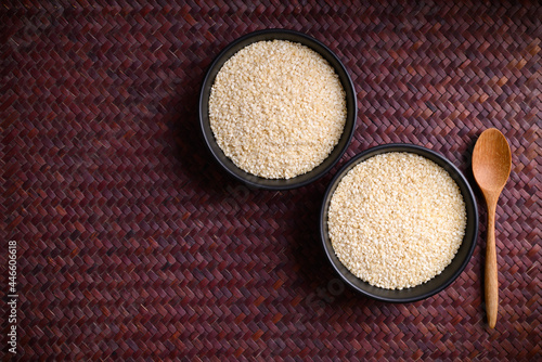 White sesame seed in a bowl with spoon, Table top view photo