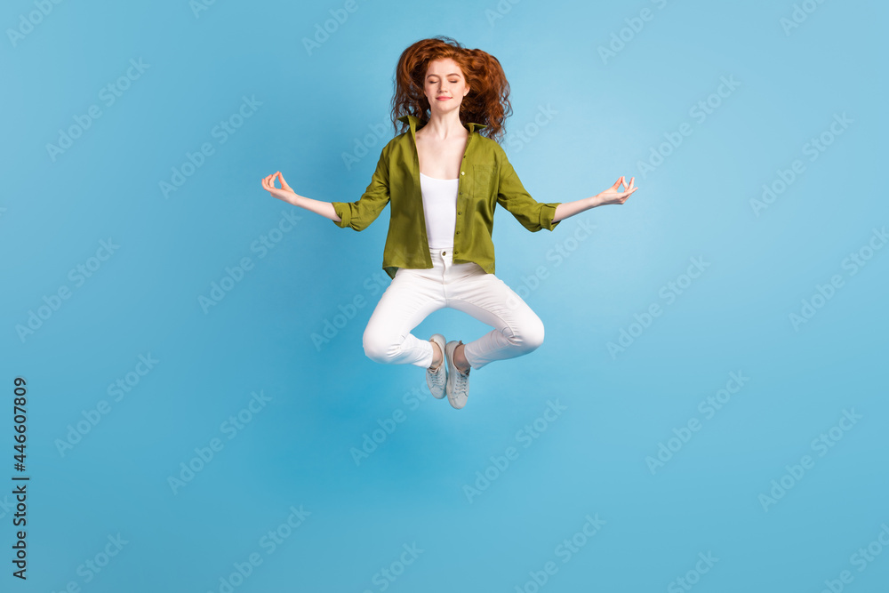 Full length body size view of attractive dreamy calm girl jumping meditating isolated over pastel blue color background Full length body size view of attractive dreamy calm girl jumping meditating isolated over pastel blue color background