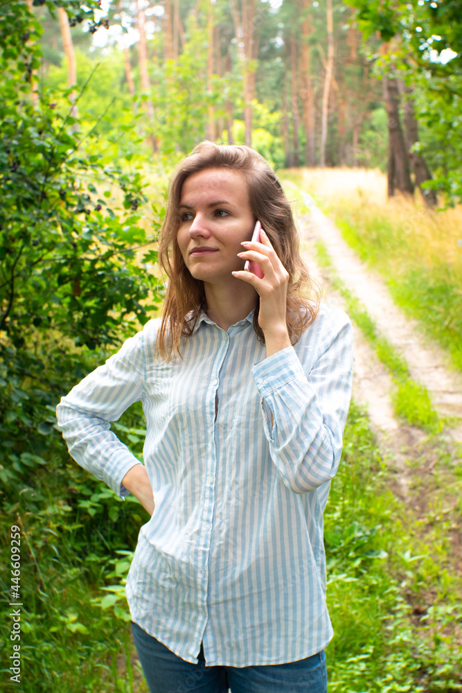 Beautiful girl with fair hair is talking on phone in forest. Young woman lost on the nature. No signal phone connection. Beautiful girl with fair hair is talking on phone in forest. Young woman lost on the nature. No signal phone connection.