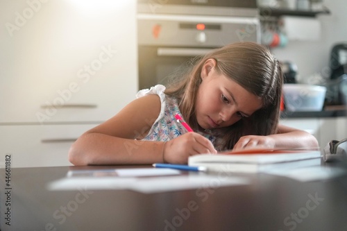 young girl doing her homework in an apartment
