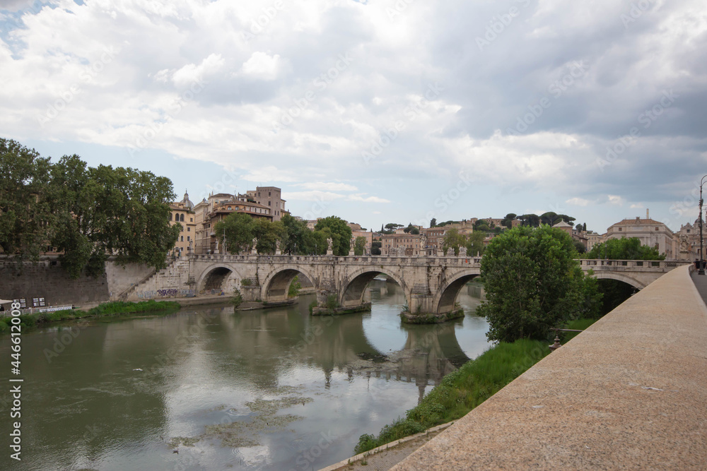 Photoscape of St. Angelo Bridge on cloudy day in summer 2021 Italy.Pedestrian bridge, built in 134 A.D., with travertine marble fascias and spanning the River Tiber.