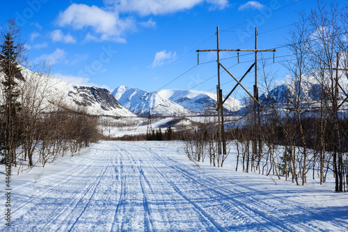 winter road in the polar mountains and old electricity pilars photo