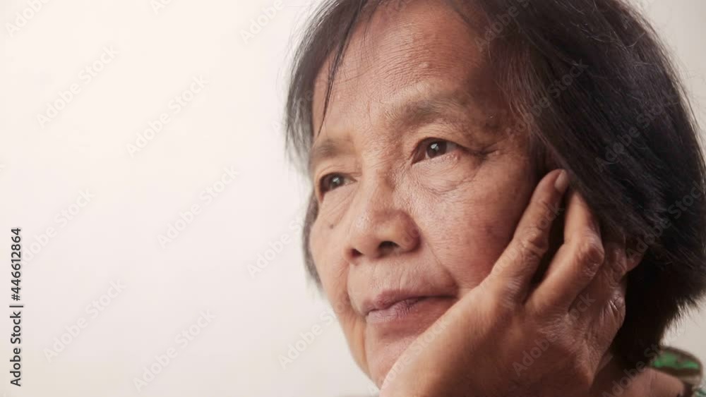 Close-up of an Asian elderly woman's face Sitting with hands on cheeks, feeling stressed, worried, afraid of getting sick. Elderly people have short-sightedness problems, blurry vision. Close-up of an Asian elderly woman's face Sitting with hands on cheeks, feeling stressed, worried, afraid of getting sick. Elderly people have short-sightedness problems, blurry vision.