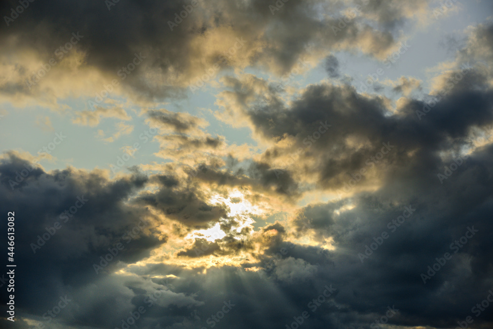 Moody cloudy sunset sky with sun beam