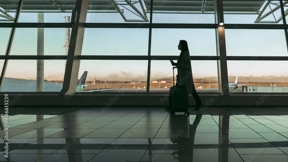Fototapeta premium Silhouette of a traveler walking at airport