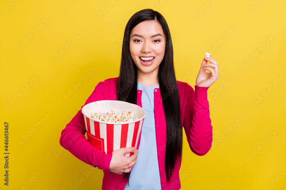 Photo of funny brunette hair young lady eat pop corn wear pink sweater isolated on yellow color background
