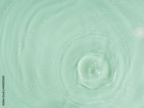 Aqua green water surface color background with ripples, circles and drops