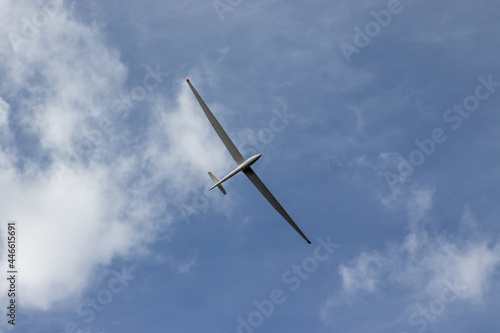 Glider against blue cloudy sky. Single seat high performance sailplane.