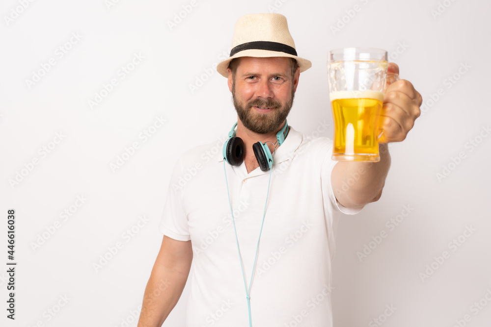 Young attractive caucasian man in casual clothes wearing white hat holding beer against white background. Concept for beach vacation holiday. Young attractive caucasian man in casual clothes wearing white hat holding beer against white background. Concept for beach vacation holiday.