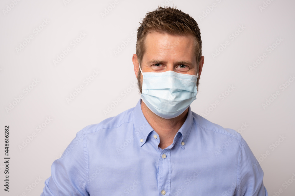 Portrait of handsome young businessman with surgical medical mask looking at camera. Portrait of handsome young businessman with surgical medical mask looking at camera.