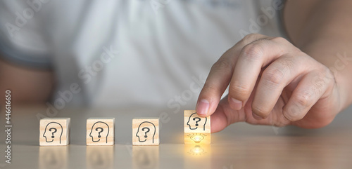 concept of brainstorming to introduce new ideas between teams to communicate creativity and innovation. Businessman flipping wooden cube blocks by hand with the human head symbol and light bulb icon.