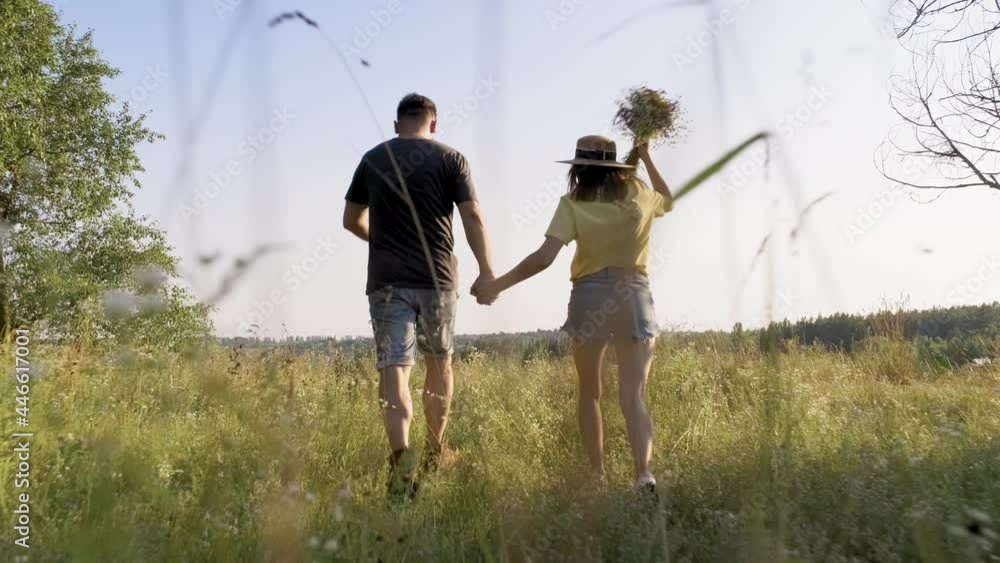 Happy middle aged couple running together holding hands, back view Happy middle aged couple running together holding hands, back view