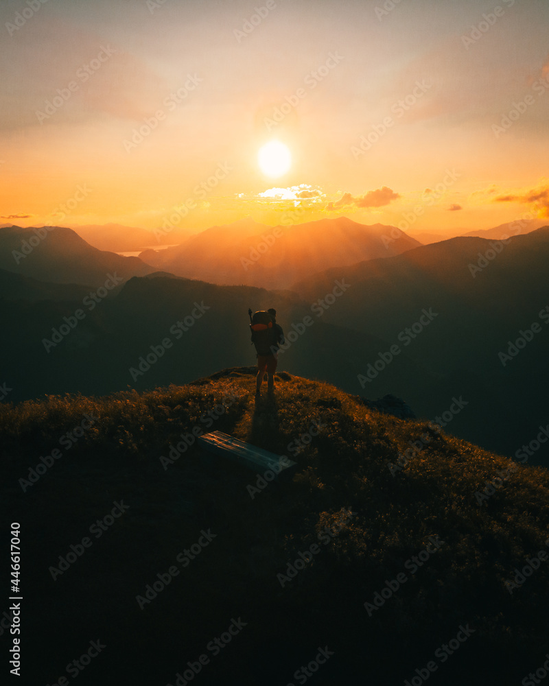 Hiker stand on Mountain Peak watching the Sunset in Austria