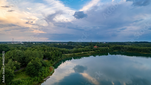 Aerial view of a beautiful and dramatic sunset over a forest lake reflected in the water  landscape drone shot. Blakheide  Beerse  Belgium. High quality photo