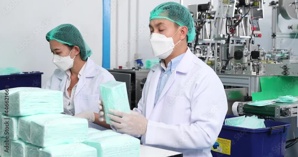 Workers are packing masks in boxes for delivery to customers. Industry factory and people concept. Indoors Workers are packing masks in boxes for delivery to customers. Industry factory and people concept. Indoors