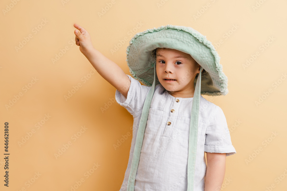 White boy with down syndrome in hat pointing finger aside White boy with down syndrome in hat pointing finger aside
