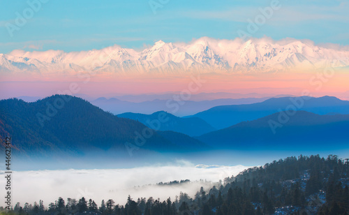 Amazing blue mountains over the white clouds with gorgeous blue sky in the background