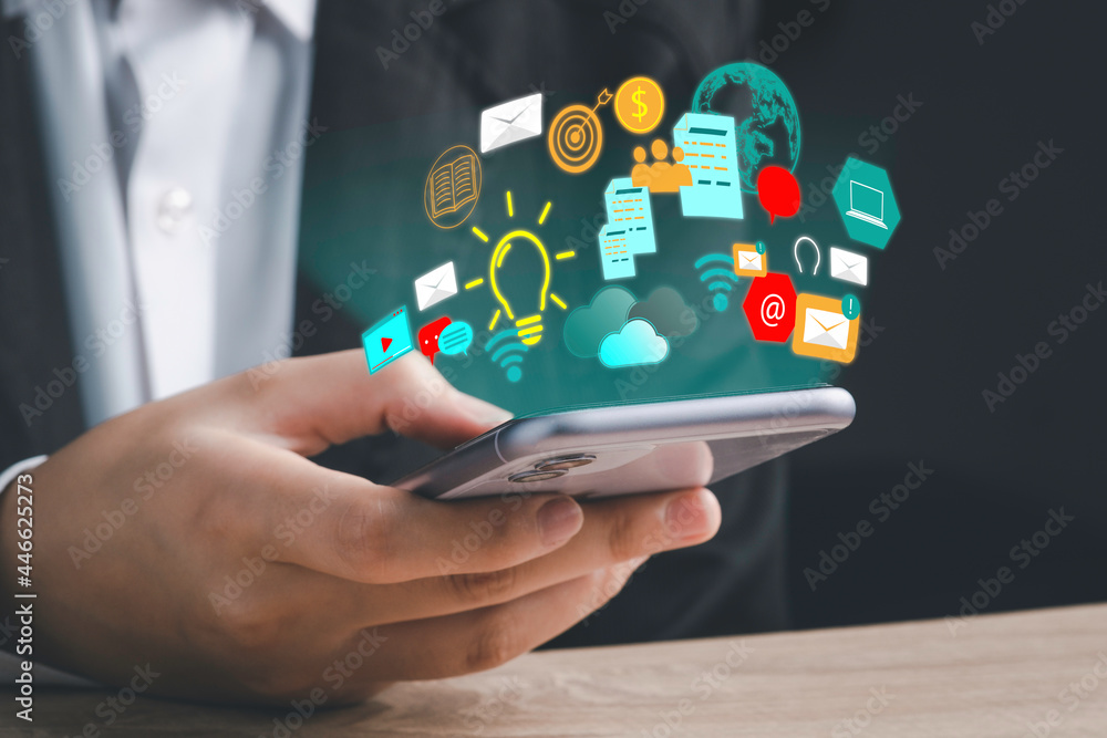 Digital marketing strategy idea concept. Content creator holding a smartphone and great creative idea for target with virtual icon financial reports. Digital marketing strategy idea concept. Content creator holding a smartphone and great creative idea for target with virtual icon financial reports.