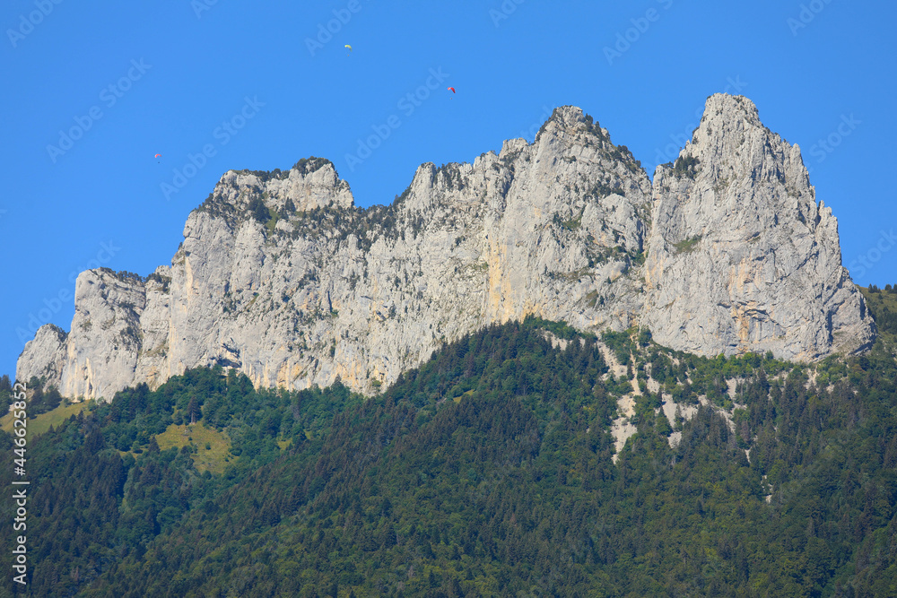 Top view of mountain peaks with blue sky and parachutes in  summer