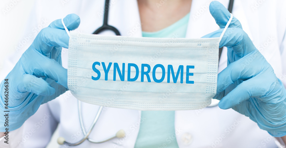 on the text SYNDROME protective mask in the hands of a doctor, medical concept on the text SYNDROME protective mask in the hands of a doctor, medical concept