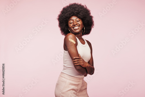 Fotografi Laughing African woman with a vaccine bandage