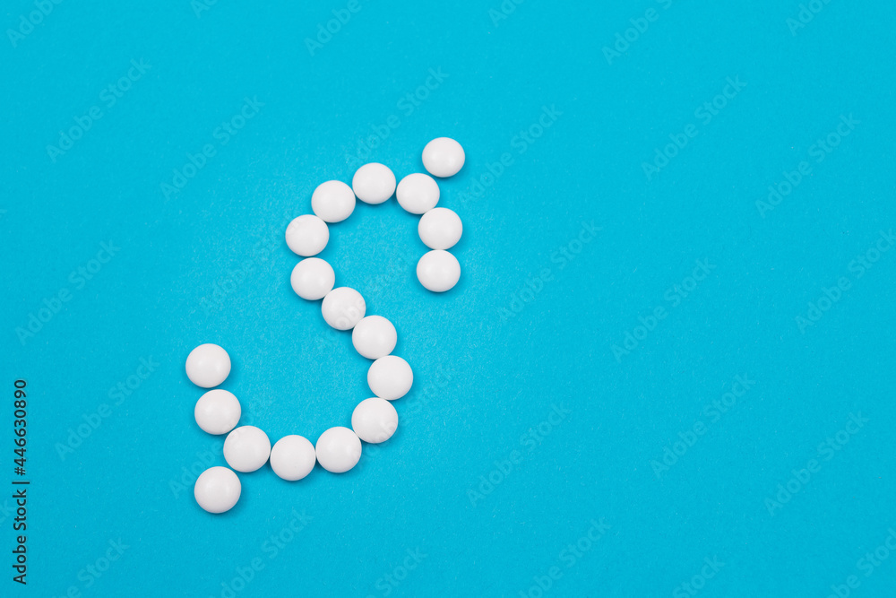 Global Pharmaceutical Industry and Medicine Business - Dollar Symbol Made from White Pills Lying on Blue Background