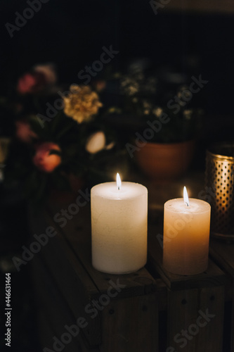 Close-up of wax candles burning with a flame stand on the table at night. Funeral ritual. Church service.