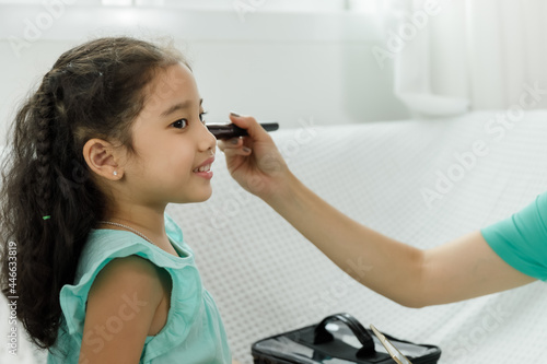Mother and daughter applying makeup