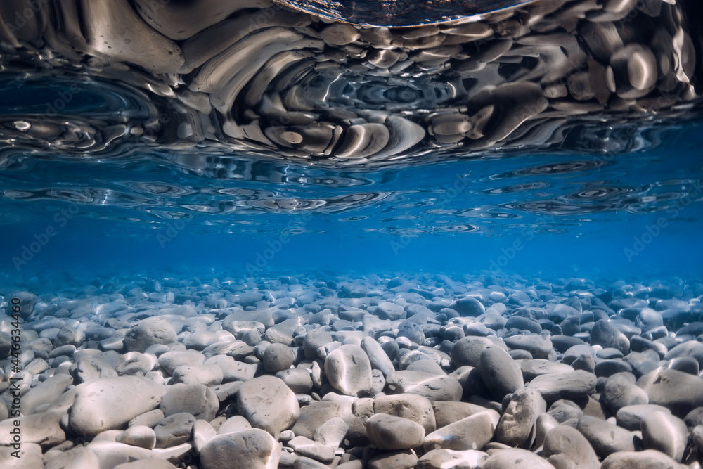 Obraz premium Underwater view with stones bottom, reflection in sea water. Ocean background