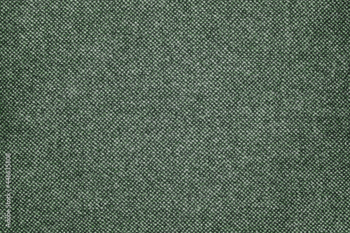 Military dark green fabric alternated with lighter tones. Fabric surface in green tones.