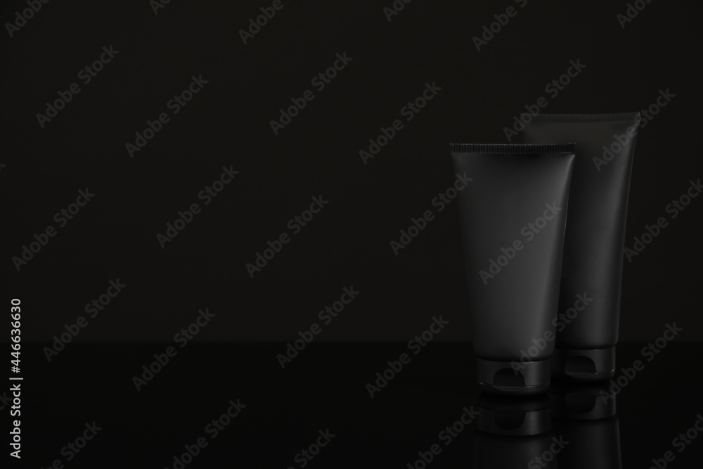 Tubes of men's facial cream on black background. Space for text Tubes of men's facial cream on black background. Space for text