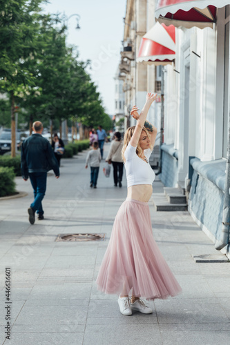beautiful blonde woman dancing to music on the street alone