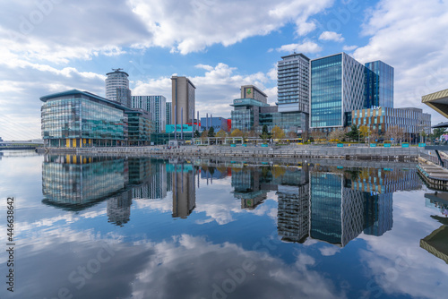 View of MediaCity and clouds reflecting in water in Salford Quays, Manchester, England photo