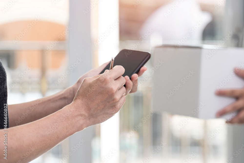 Women use electronic pen Sign and check list on smartphone after check pick up package from the post office transport,stay at home concept Women use electronic pen Sign and check list on smartphone after check pick up package from the post office transport,stay at home concept