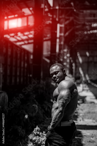 Handsome strong bodybuilder outdoor looking to his side. Black and white picture of muscular man.