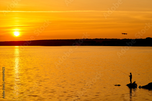 Beautiful sunset on a lake. Outdoor yellow evening scenery. © Vadim