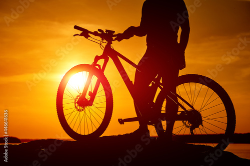 Sunset shadow of cycling man. Silhouette of evening biker.