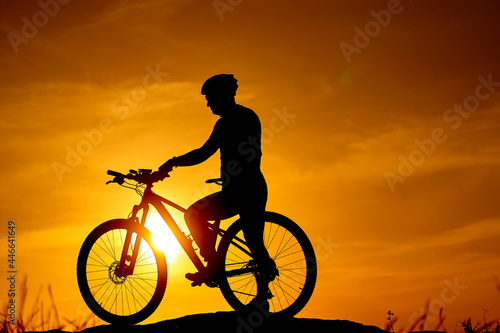 Silhouette of evening biker. Sunset shadow of cycling man.