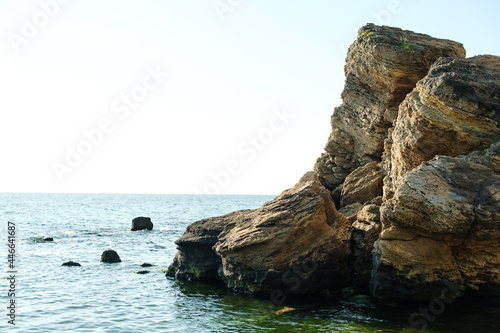 Rocks in the sea water against blue sky in summer.