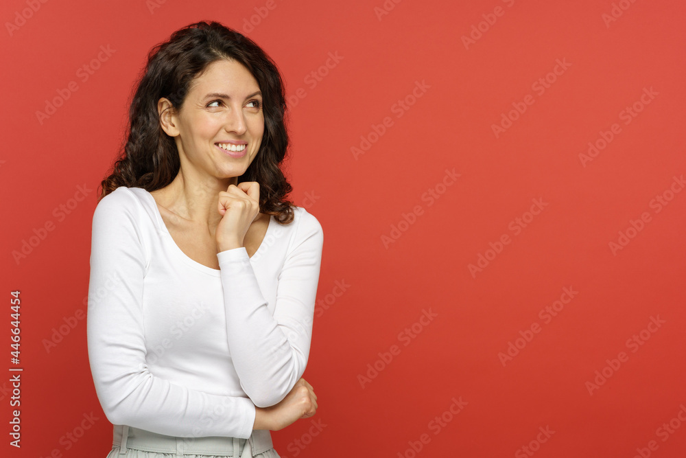 Portrait of surprised woman with open mouth and hand at chin, looking at blank copy space for advertisement. Excited positive young woman surprised by low price and discount on red studio background Portrait of surprised woman with open mouth and hand at chin, looking at blank copy space for advertisement. Excited positive young woman surprised by low price and discount on red studio background