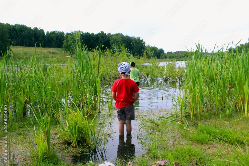 Children are standing in the water with their backs. Children are standing in the water with their backs.