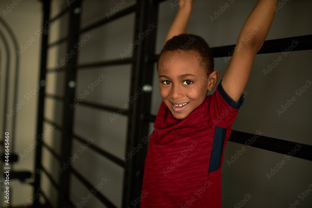 Active, full of energy child boy smiling doing physical exercise on wooden stair. Fun and entertainment for school kids, good for health. Sport. childhood, activity, leisure concept. Copy space