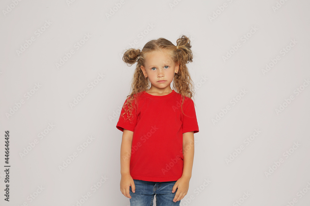 a beautiful blonde girl with ponytails in a red T-shirt shows various emotions sadness ,surprise, fear ,happiness