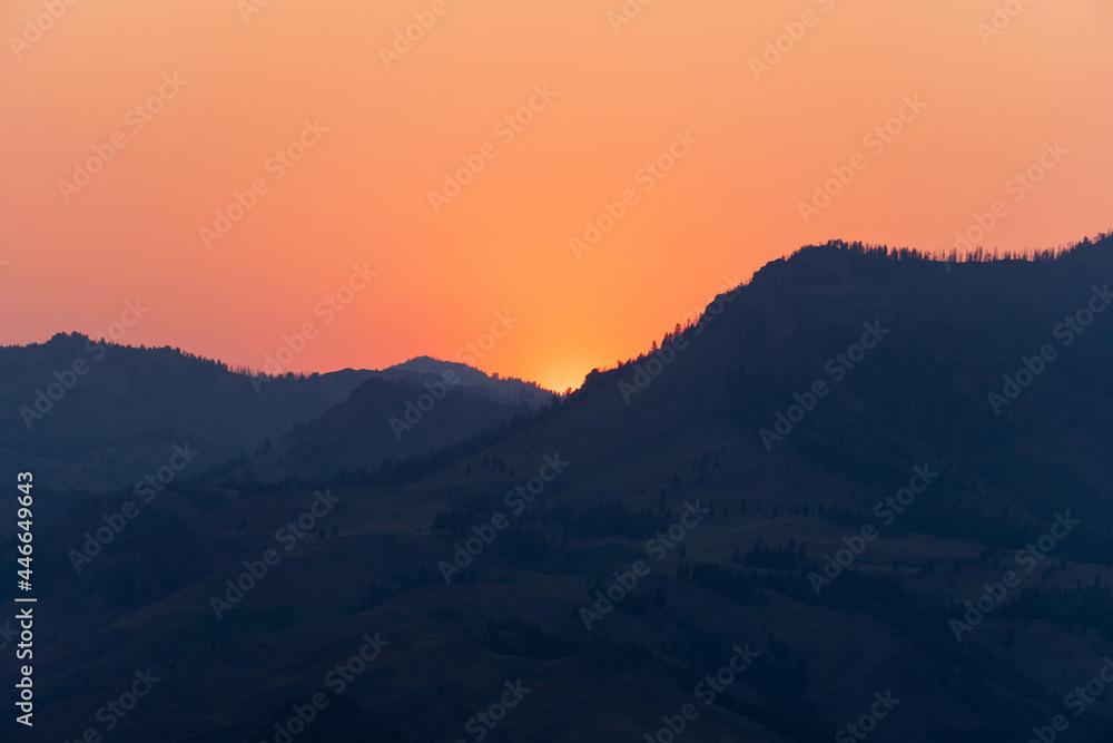 Beautiful Sunset with the Sun Peaking through the Sun Valley Idaho Mountains.