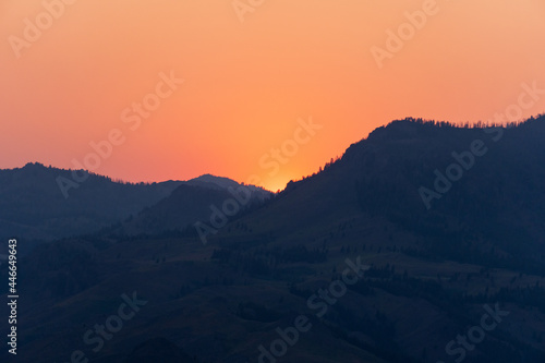 Beautiful Sunset with the Sun Peaking through the Sun Valley Idaho Mountains.