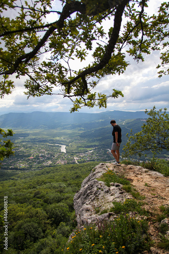 Fototapeta Naklejka Na Ścianę i Meble -  hiker in the mountains,  мужчина на скале в горах, мужчина со спины на горе