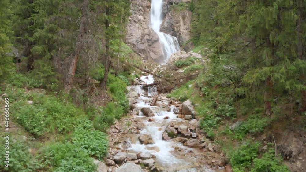 Aerial view of Burkhan Bulak waterfall. Burkhan-Bulak is the highest waterfall in Kazakhstan. Mountains of the Dzhungarskiy Alatau. The camera moves to the waterfall and goes up. Aerial view of Burkhan Bulak waterfall. Burkhan-Bulak is the highest waterfall in Kazakhstan. Mountains of the Dzhungarskiy Alatau. The camera moves to the waterfall and goes up.