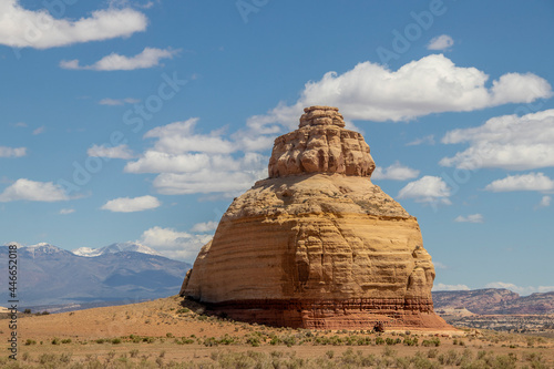 Huge round domed rock in a field in Colorado USA known as Church rock or the Teapot dome with blue mountains in the background.