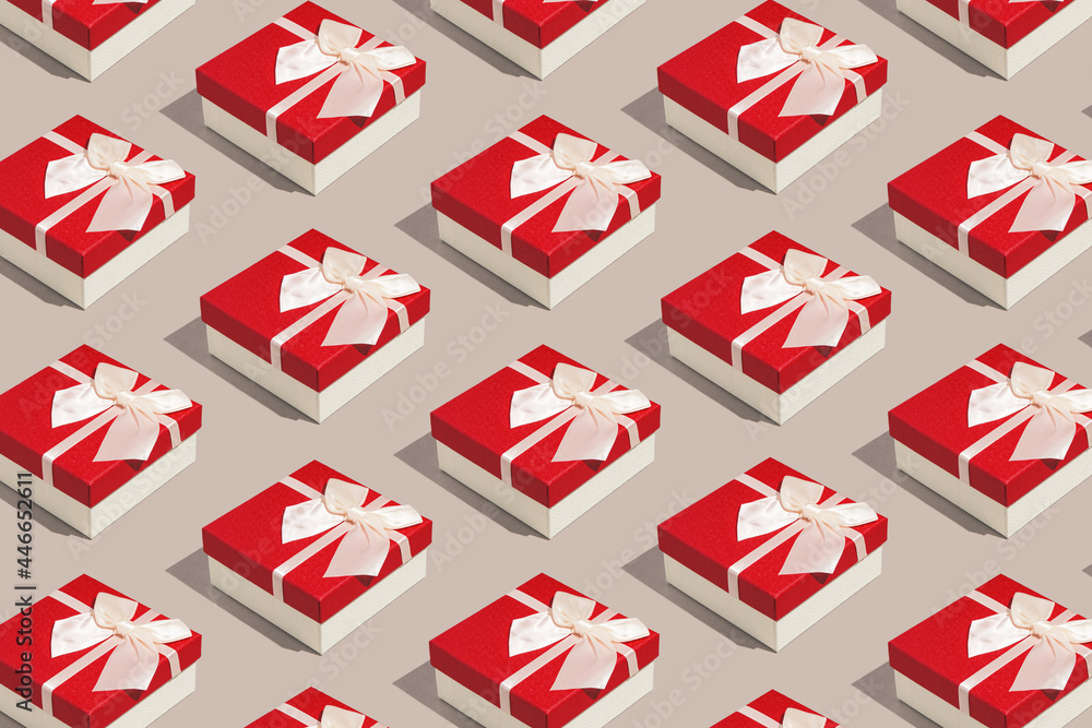 Creative pattern made with present boxes with bows on pastel beige background. Christmas or birthday gift concept. Minimal style. Flat lay. Top view Creative pattern made with present boxes with bows on pastel beige background. Christmas or birthday gift concept. Minimal style. Flat lay. Top view