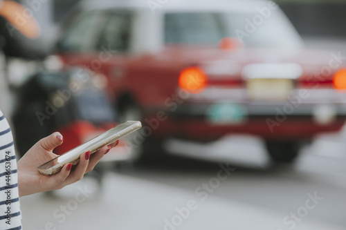 Woman with a smartphone ordering taxi cab or alternative modes of transport. photo